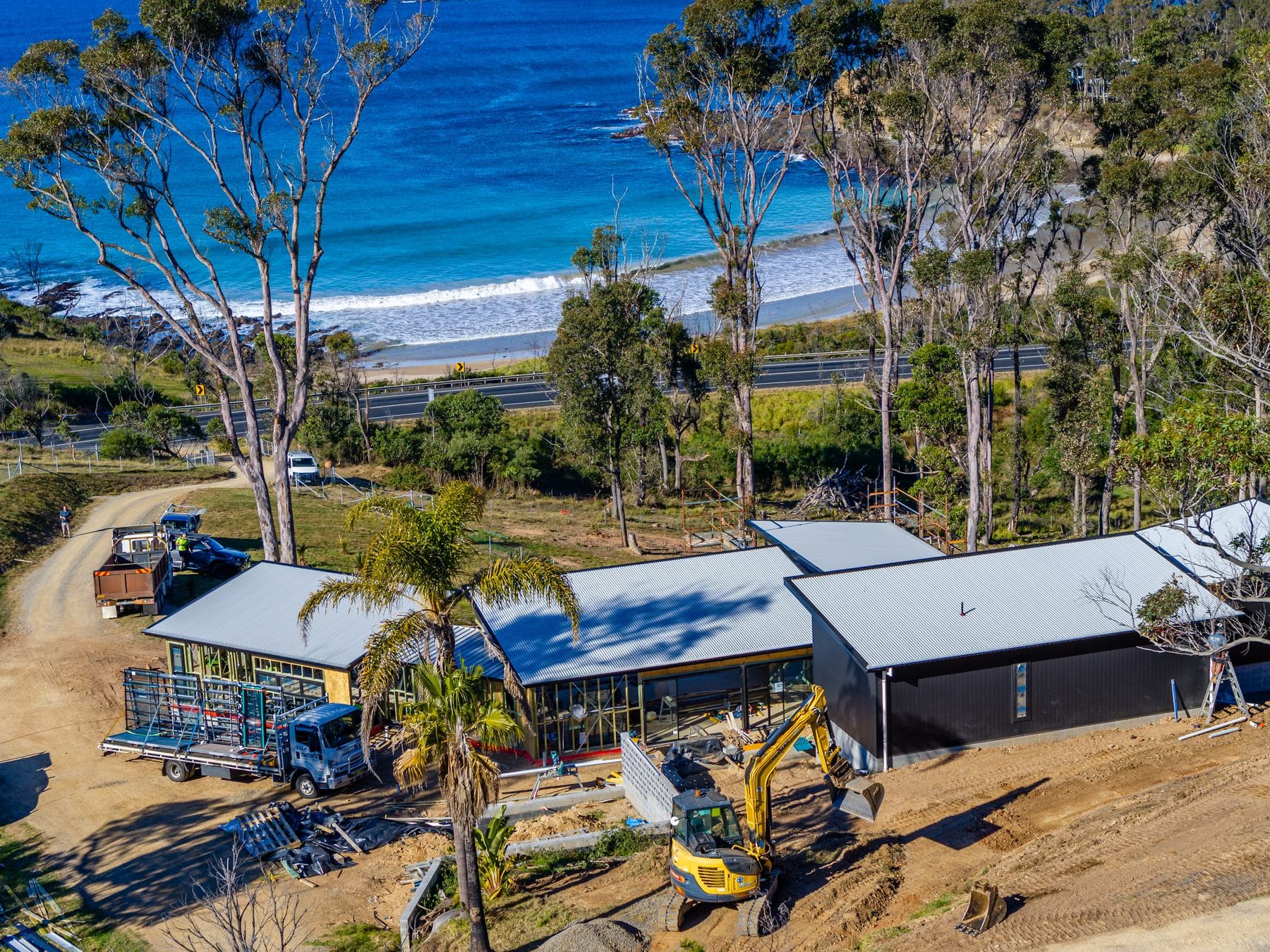 Cleared coastal site with an excavator ready for a new build, NSW South Coast