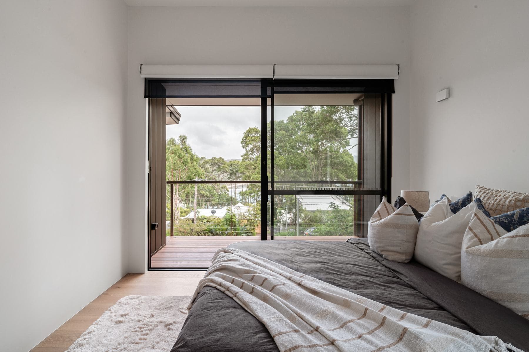 Light-filled bedroom with black-framed glazing in a high-performance Perrem home