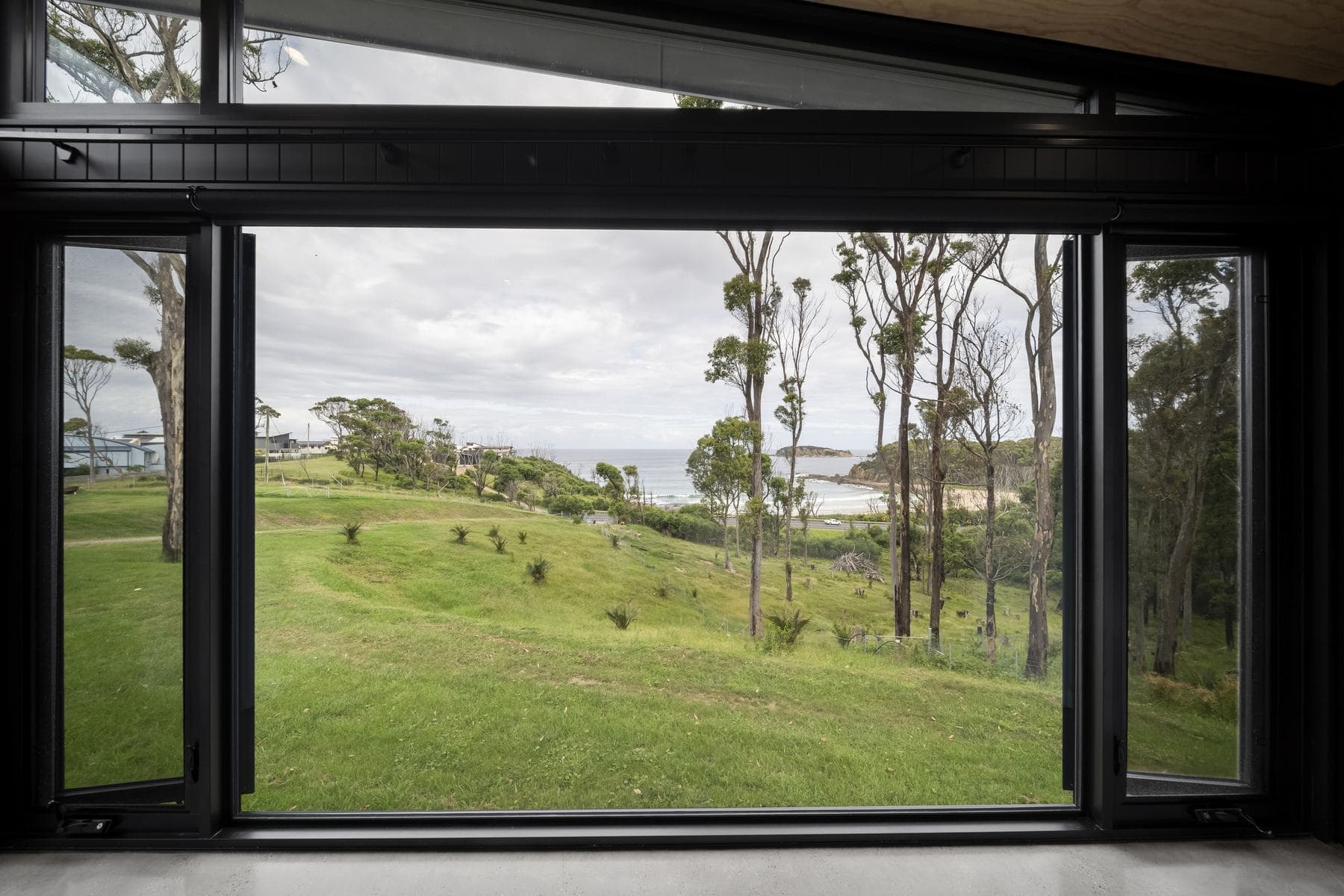 Large windows framing coastal bushland views in a sustainable Perrem home