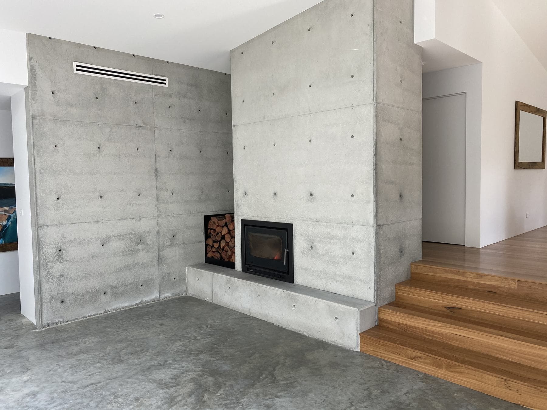 Board-marked concrete feature wall and fireplace inside a Perrem home