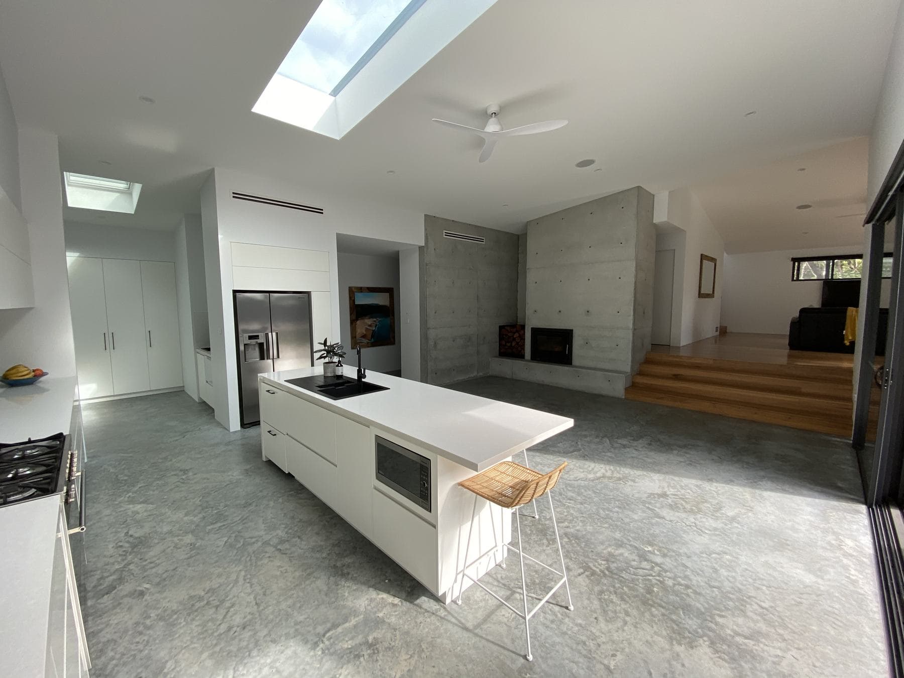 Open plan kitchen with skylights and concrete walls